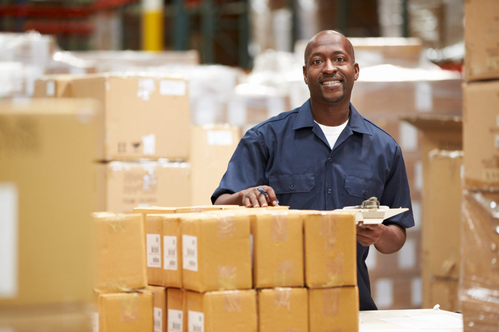 A man in blue shirt holding a box.