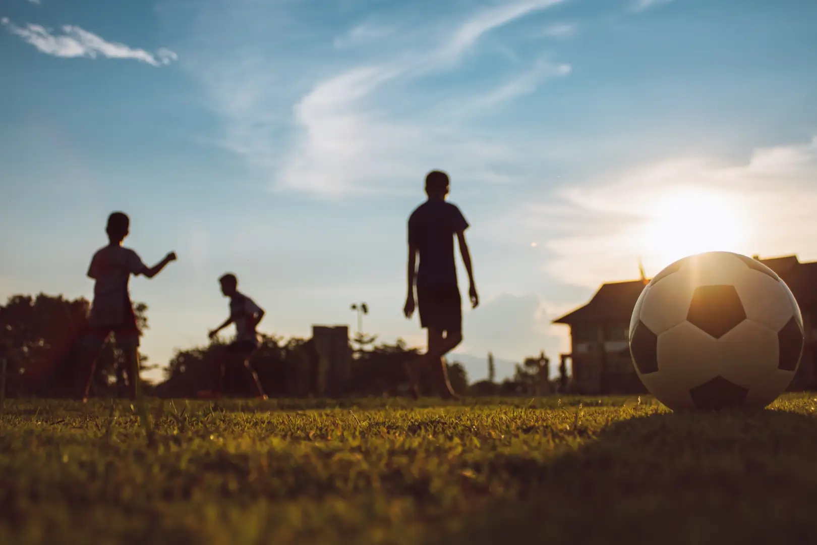 A group of people playing soccer on the grass.