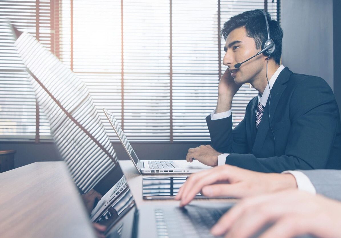 A man with headphones on sitting at a desk.